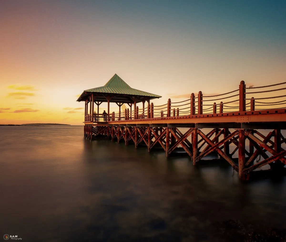 Sunrise over the calm sea at Mahebourg waterfront jetty in Mauritius