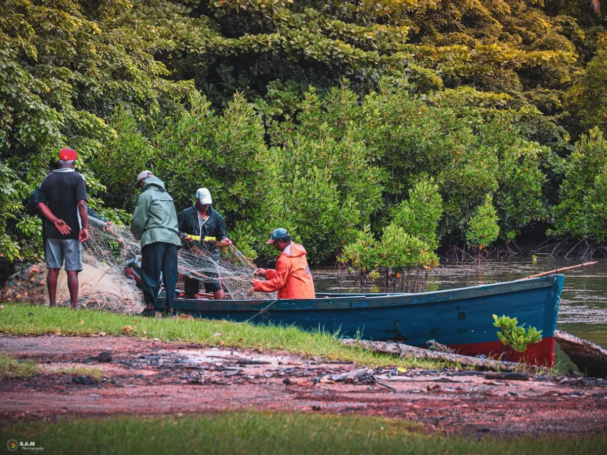 Fishermen in Mahebourg, Mauritius, preparing fishing nets near boats in the early morning