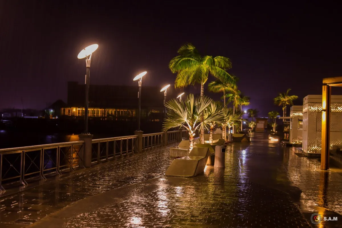 Night view of Caudan waterfront pathway illuminated by street lights near Port Louis harbor in Mauritius