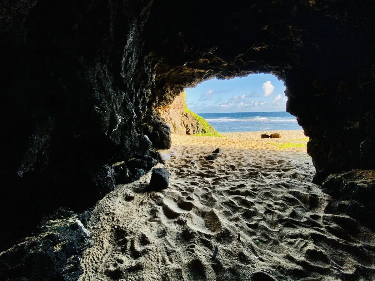 View of Gris Gris beach in Mauritius from inside a coastal cave surrounded by rocks