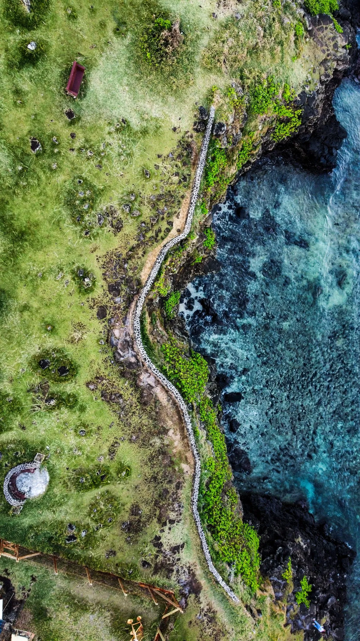 Aerial view of colorful cliff and safety wall along the shore in Mauritius