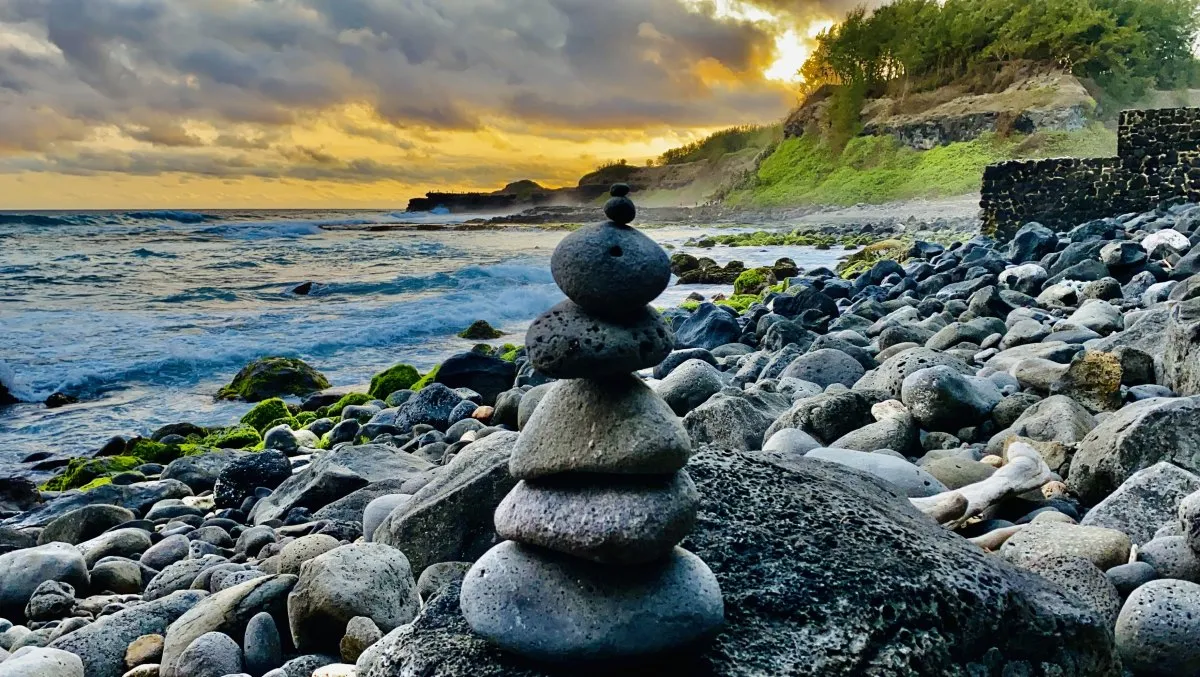Rocky beach with stacks of rocks at Baie des Negresses in Mauritius during sunset