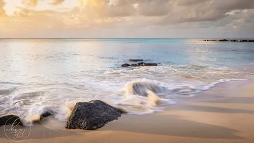 Sea reaching rocky shore at La Cuvette beach