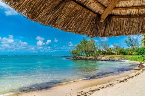 View on wild unspoilt Constance hotel beach under umbrella