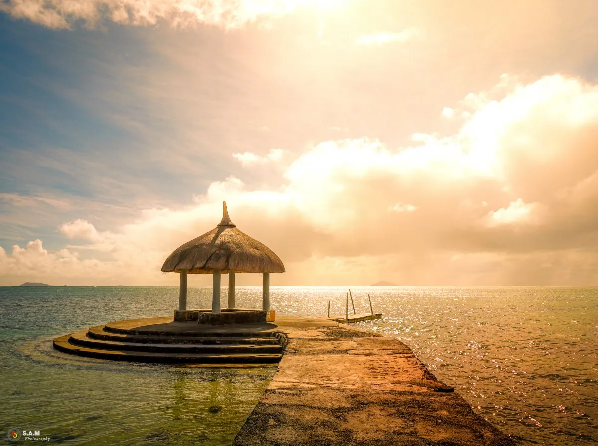 Concrete stairs and pathway leading from a jetty into the ocean at Cap Malheureux Beach, Mauritius under a faded sun
