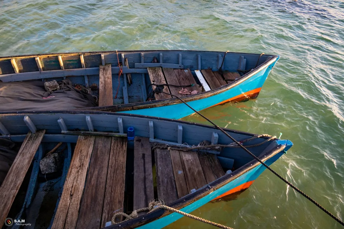 Blue fishing pirogues side by side in the Mahebourg lagoon, Mauritius