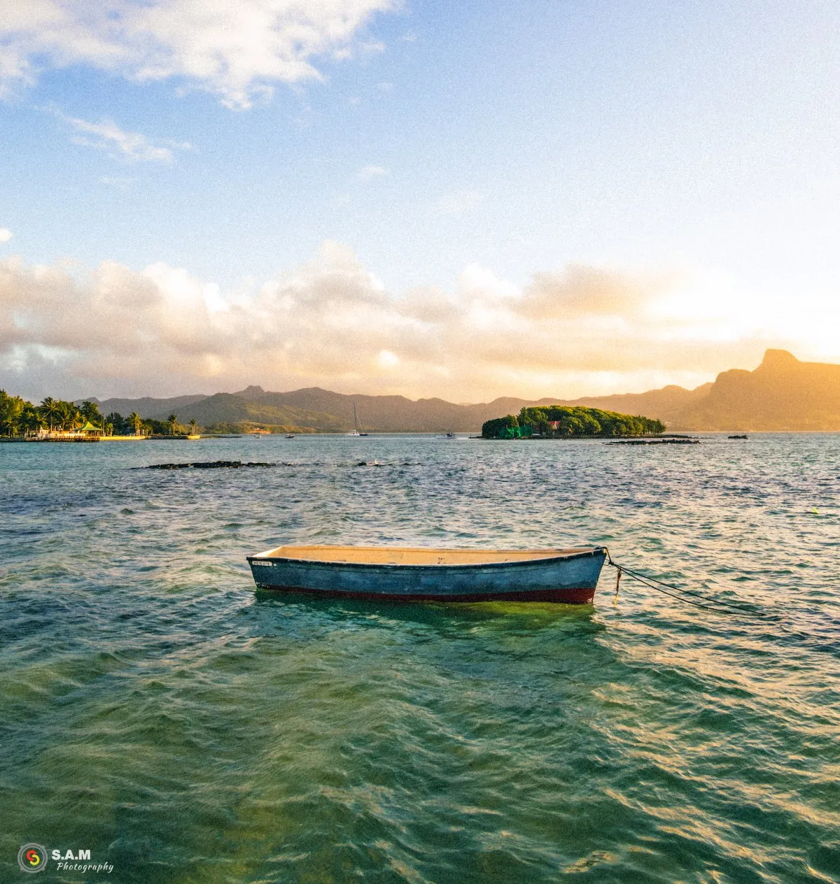 A lone pirogue floating near Mouchoir Rouge Island by Mahebourg in Mauritius under clear skies