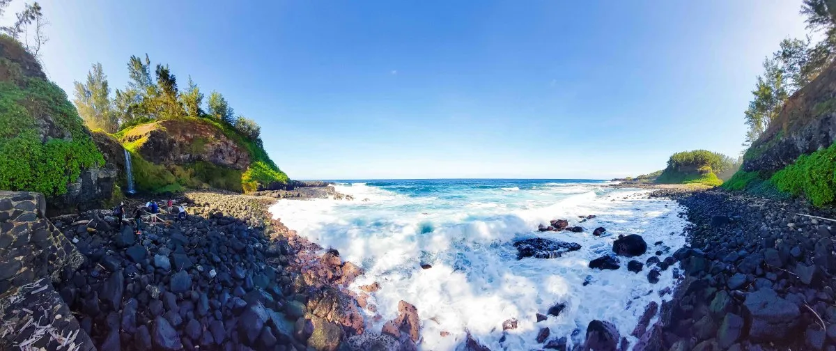 Panoramic view of waves crashing on rocky beach at Souillac in Mauritius under clear sky