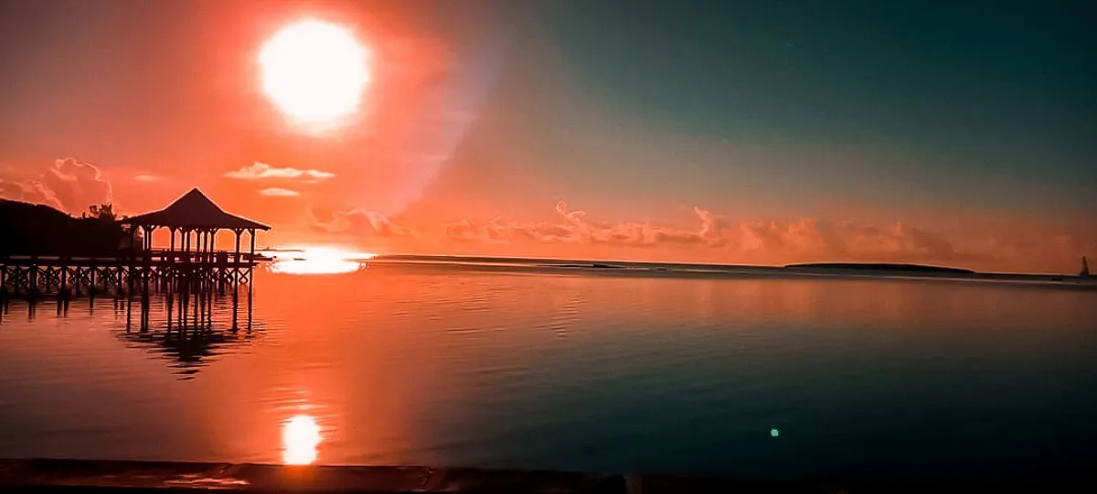 Red sunrise near the Mahebourg jetty over a calm lagoon in Mauritius