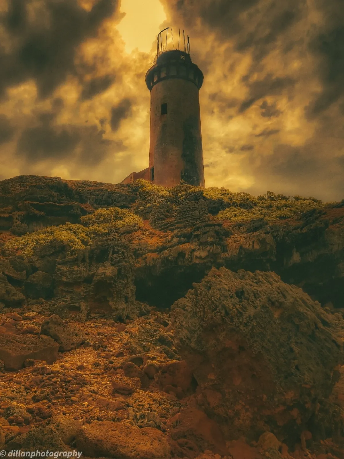 Old lighthouse on La Passe cliffs with cloudy sky in Mauritius by Dillan St Mart