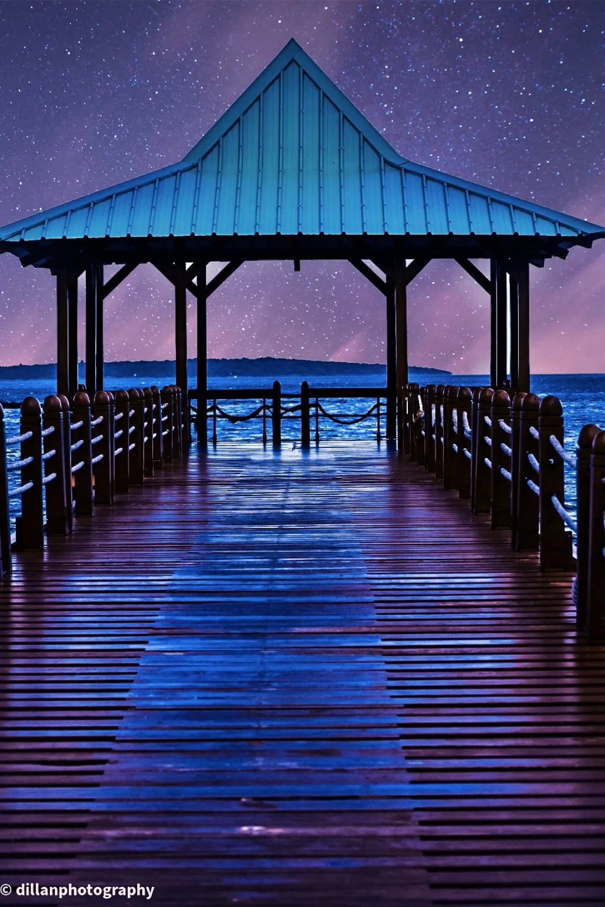 Starry night sky and seascape at wooden jetty in Mahebourg, Mauritius