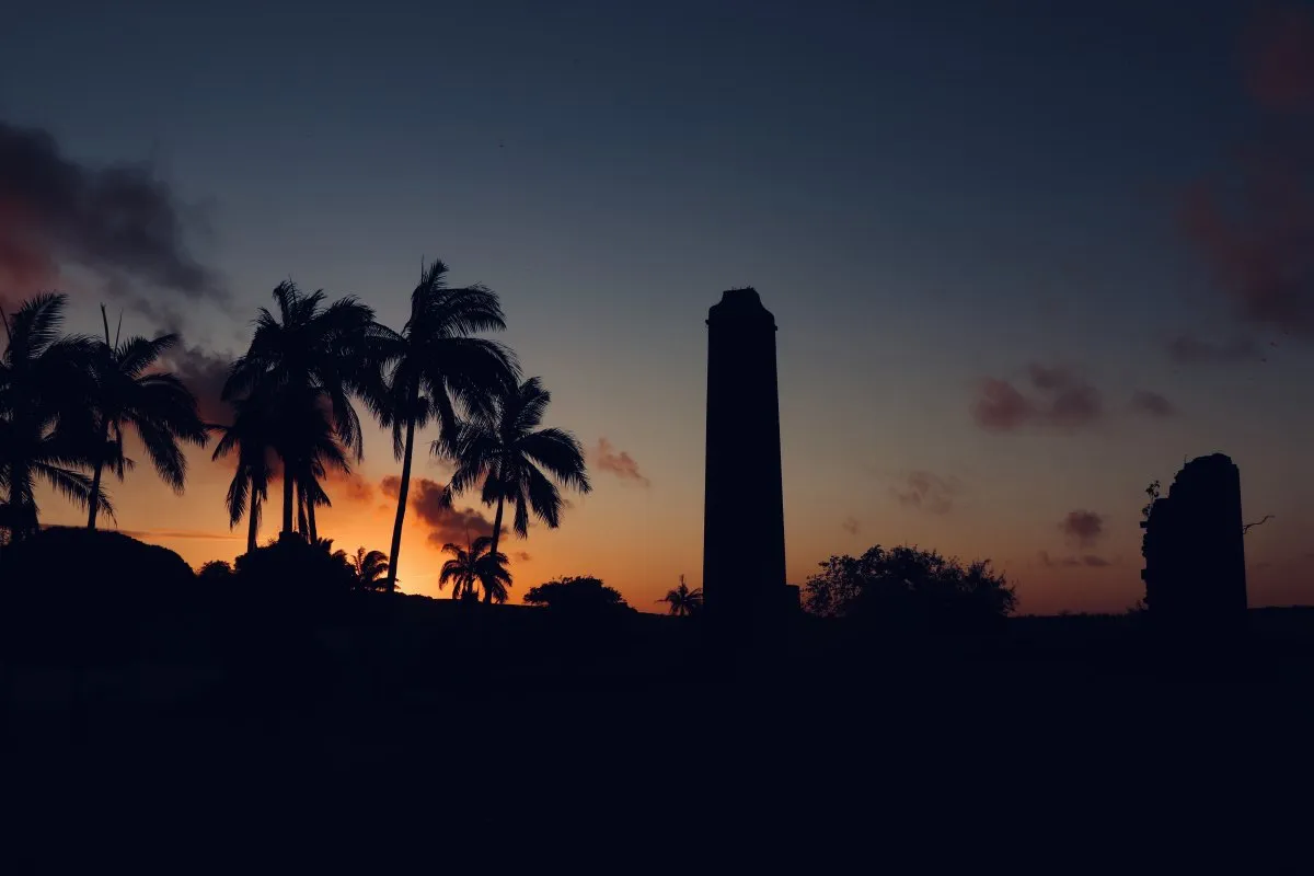Silhouette of old chimney and coconut trees at sunset in Mauritius during blue hour