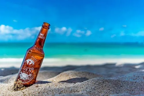 Phoenix beer bottle on Belle Mare beach under blue sky