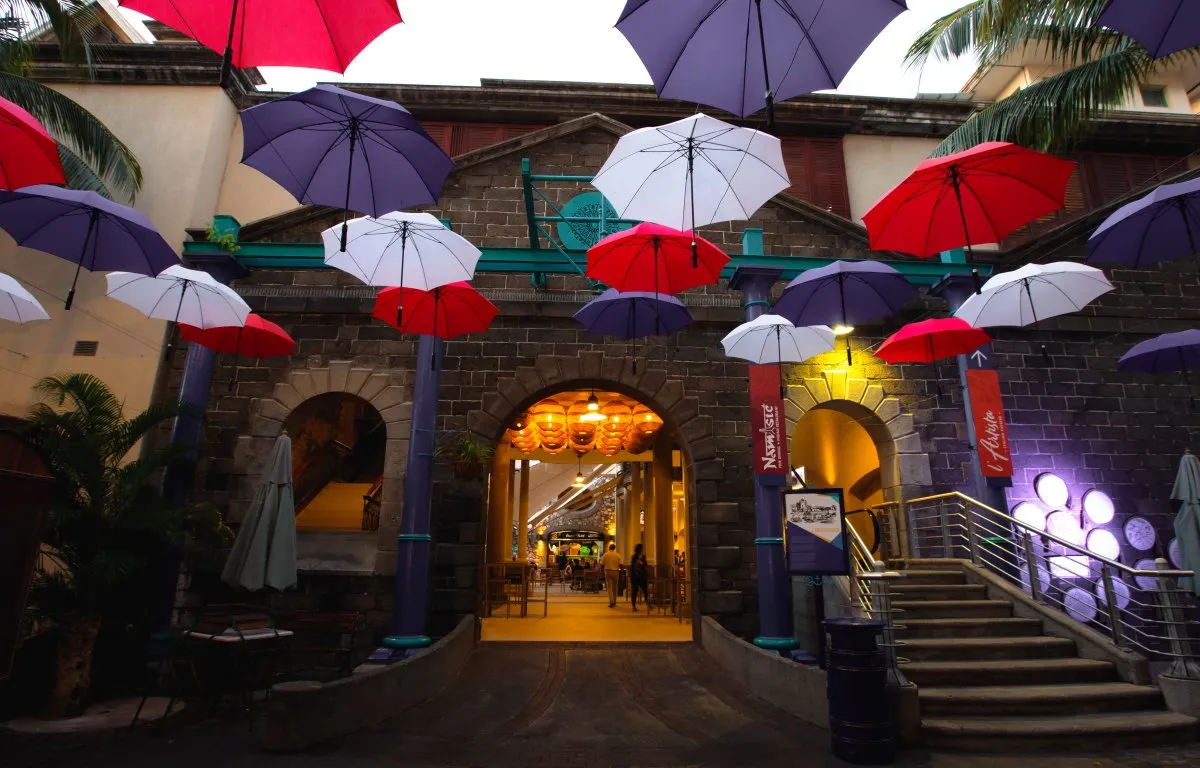 Colorful umbrellas hanging at Le Caudan waterfront near a restaurant entrance in Mauritius