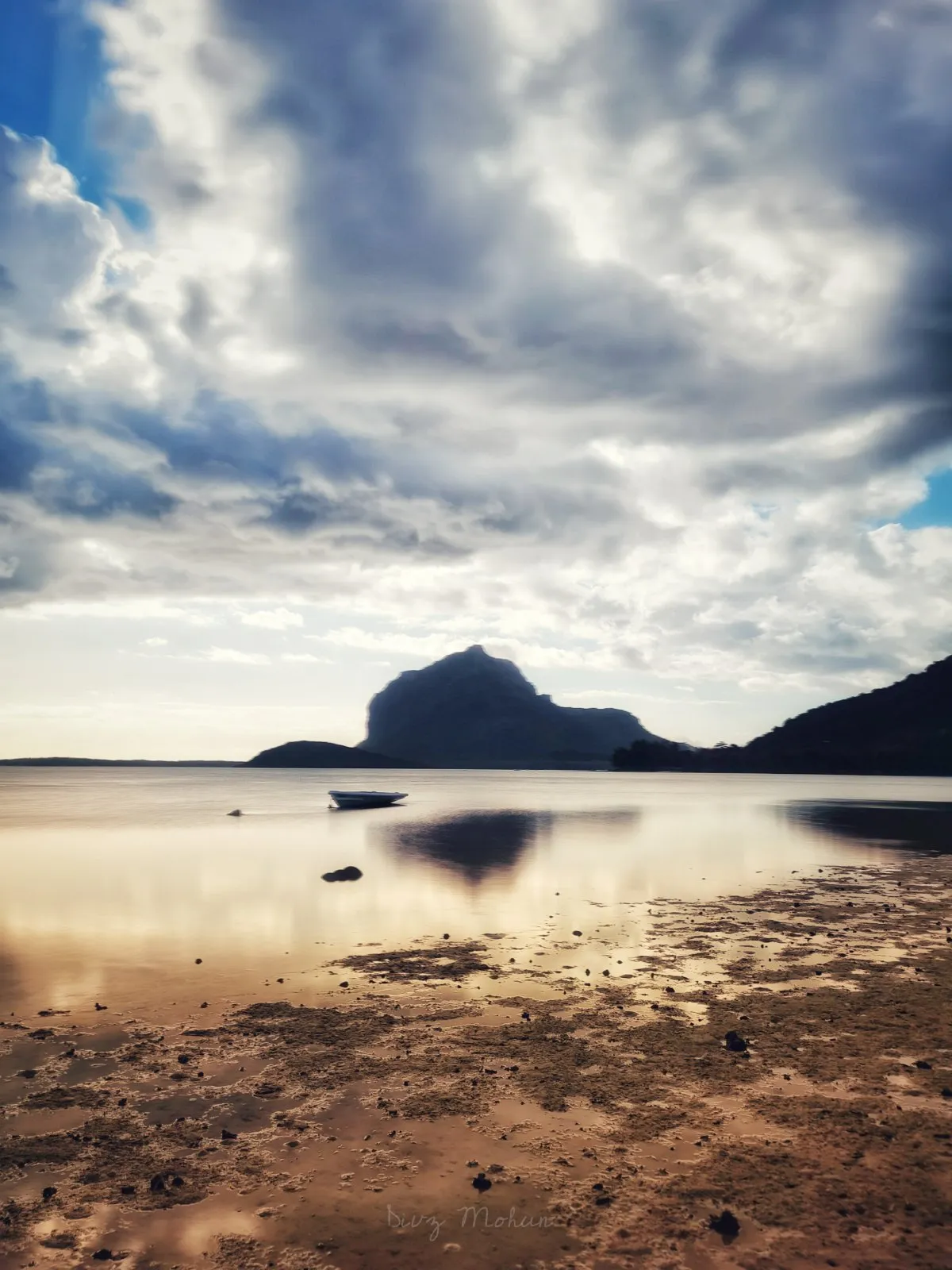 Low tide at La Prairie beach with Le Morne mountain under cloudy sky in Mauritius