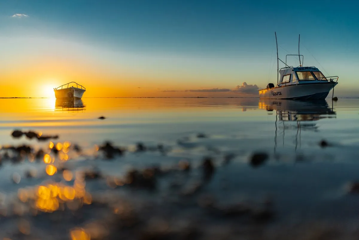 Two fishing boats moored in calm Albion sea at sunset in Mauritius