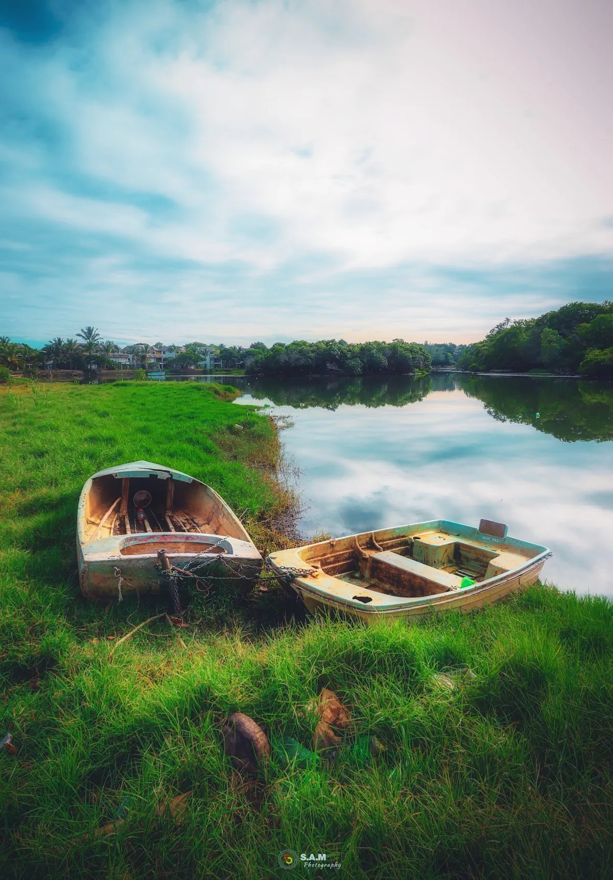 Two small dinghies tied up on the grassy shore of Tamarin River in Mauritius