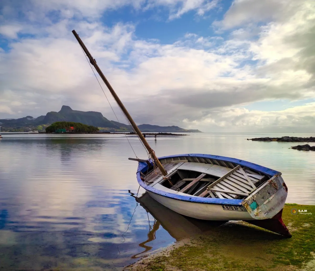 Wooden fisherman boat with mast in Mahebourg lagoon, Mauritius, during morning light