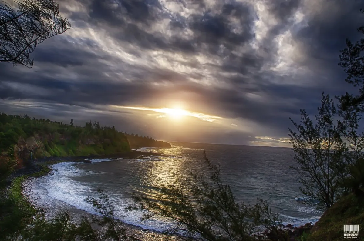 Sunrise lighting up the cliffs near Andrea Lodges in Mauritius with moody clouds and waves