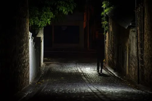 Lone figure walking in a dark alley Port Louis