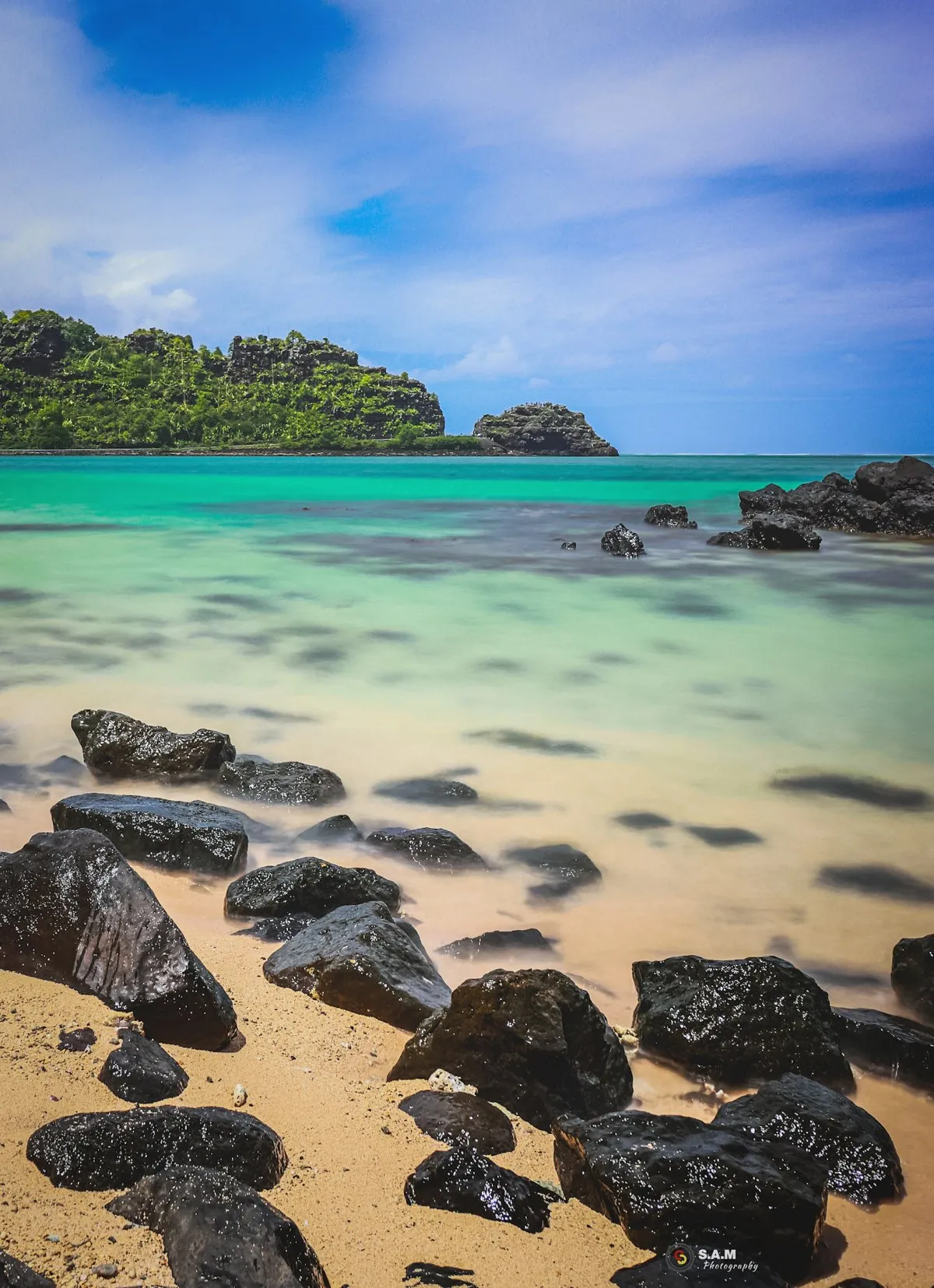 Long exposure photo of rocky Maconde beach and turquoise lagoon in Mauritius