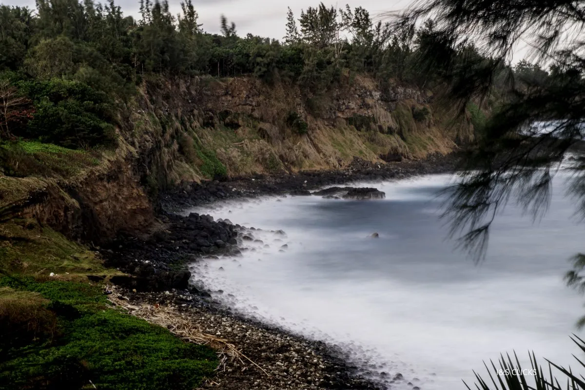 Black stone cliffs at Andrea Lodge in St. Aubin, Mauritius with waves crashing