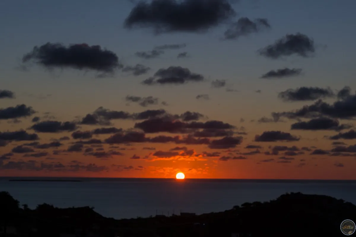 Sunset over the sea at Ile Aux Sable Island in Rodrigues, Mauritius with a glowing sun near horizon