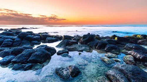 Rocky lagoon of Pointe Aux Piments at sunset