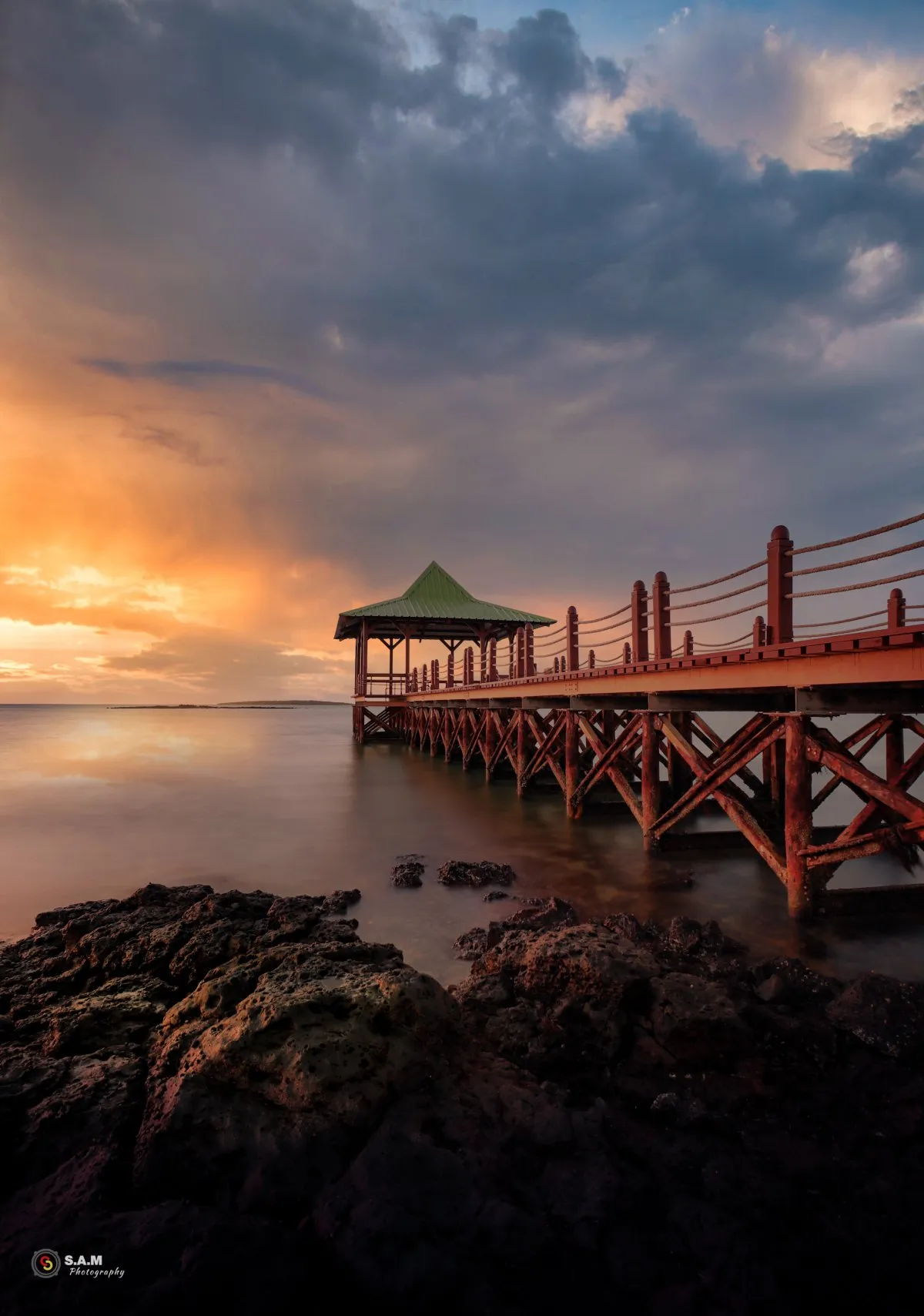 Sunrise over Mahebourg jetty with calm sea and clouds in Mauritius