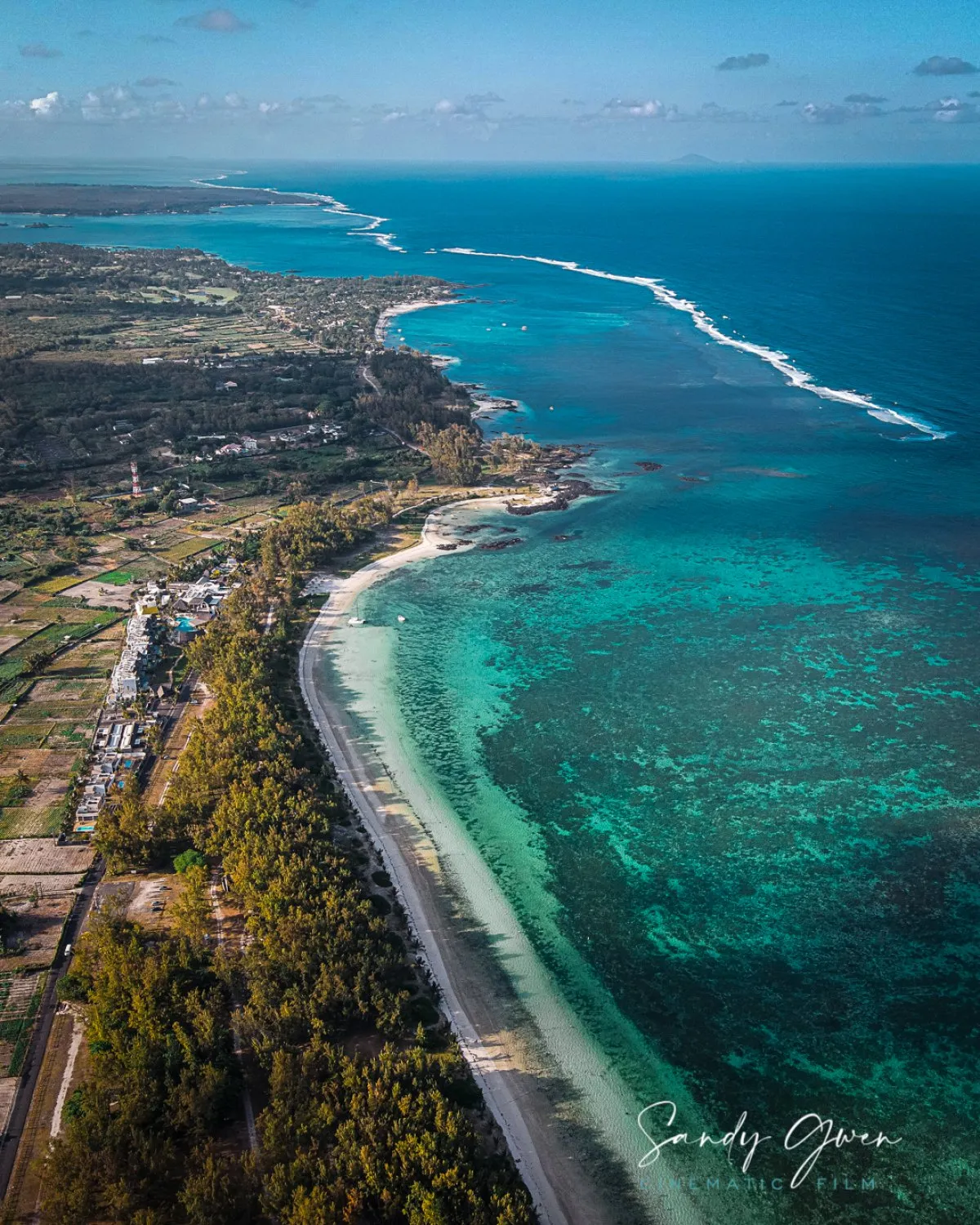 Aerial drone view of Belle Mare coast beach with trees and village in Mauritius
